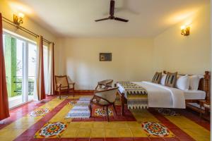 a bedroom with a bed and a large window at ama Stays & Trails Anjanagiri , Kotagiri in Kotagiri