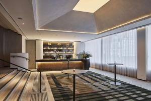 a hotel lobby with two tables and a bar at Rydges Melbourne in Melbourne