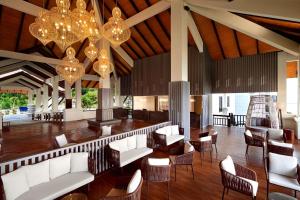 um átrio com sofás brancos, cadeiras e lustres em DoubleTree by Hilton Damai Laut em Lumut