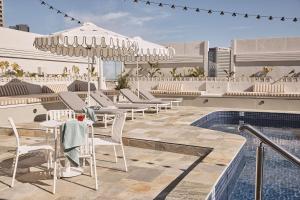 an outdoor patio with tables and chairs and a pool at Rydges Melbourne in Melbourne