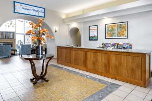 a lobby with a counter with a vase of flowers on a table at Hilton Vacation Club Scottsdale Villa Mirage in Scottsdale