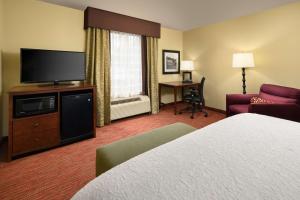 a hotel room with a bed and a flat screen tv at Hampton Inn Kimball in Kimball