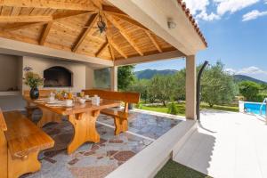 an outdoor dining area with a wooden table and benches at VILLA BEYBE with Jacuzzi, large private pool 50m2, BBQ,free WIFI, 3 bedrooms in Gata
