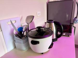 a coffee pot sitting on a counter next to a microwave at Gibzon's Invitation Suites near Mactan airport in Mactan