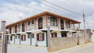 un edificio con una valla de piedra delante de él en Pouso da Rita - Tiradentes, en Tiradentes