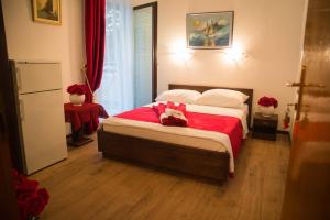 1 dormitorio con 1 cama grande con manta roja en Apartmani Vila Filipović, en Živogošće