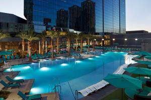 a pool with chairs and umbrellas at a hotel at Hilton Club Elara Las Vegas in Las Vegas