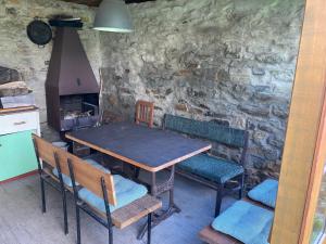 a table and chairs in a kitchen with a stone wall at Pension Pošta in Branná