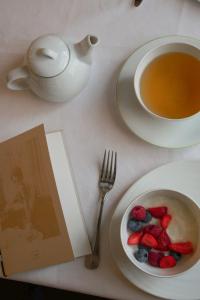a table with a plate of fruit and a cup of tea at Hôtel de Cavoye in Fontainebleau