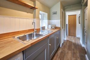 a kitchen with a sink and a wooden counter top at Host & Stay - The Old Post Office in Chatton