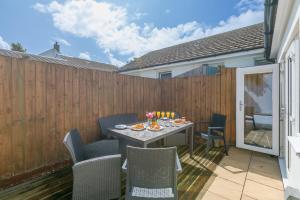 a patio with a table and chairs and a fence at Carvean in Carbis Bay