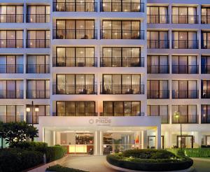 een groot appartementencomplex met veel ramen bij Bangna Pride Hotel & Residence in Bangkok