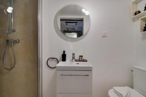 bagno bianco con lavandino e specchio di CMG Palais Royal / Musée du Louvre a Parigi