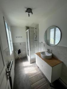 Un baño blanco con lavabo y espejo. en Appt cosy vue mer Malo-Les-Bains, en Dunkerque 10 fotos más