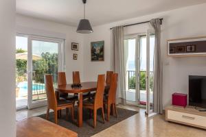 a dining room with a table and chairs and a television at Holiday Home Kvarner in Ičići