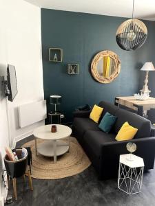 - un salon avec un canapé noir et une table dans l'établissement Appt cosy vue mer Malo-Les-Bains, à Dunkerque