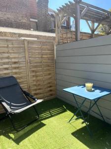 une table bleue et une chaise dans l'arrière-cour dans l'établissement Appt cosy vue mer Malo-Les-Bains, à Dunkerque