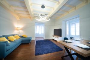 a living room with a blue couch and a table at Apartamento con garaje en el centro de Zumaia in Zumaia