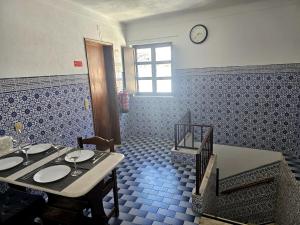 a dining room with a table and a clock on the wall at A Casa D'eles in Póvoa e Meadas