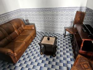 uma sala de estar com um sofá de couro castanho e uma mesa em A Casa D'eles em Póvoa e Meadas