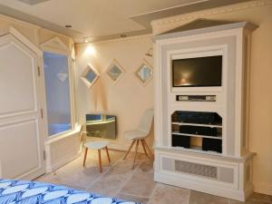 a bedroom with a tv in a white wall at Appartement Moderne & Spacieux Hypercentre CAEN in Caen