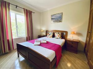 a bedroom with a large bed and a window at Quarteira Central 1 by Homing in Quarteira