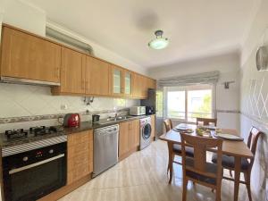 a kitchen with a table and a dining room at Quarteira Central 1 by Homing in Quarteira