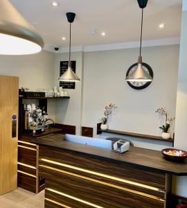 una cocina con una encimera con dos luces colgantes en Angus Hotel en Londres