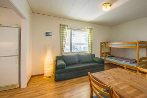 a living room with a couch and a bunk bed at Sandsjögården Holiday Resort in Blattniksele