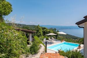 a villa with a swimming pool and a view of the water at Holiday Home Kvarner in Ičići