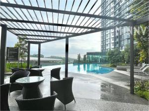 un patio con mesa y sillas y una piscina en Parkland Batu 11 near MRT 5-6PAX Free Parking, en Cheras