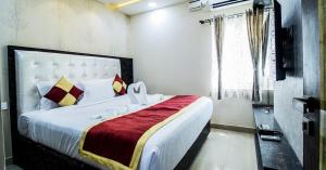 SR BOUTIQUE STAY SERVICE APARTMENT في كويمباتور: غرفة نوم بسرير كبير مع بطانية حمراء