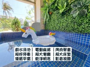 een plastic speelgoedeenhoorn in een zwembad bij Have FUN villa in Hengchun