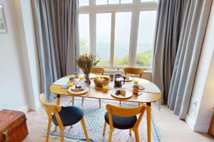 uma sala de jantar com uma mesa e cadeiras e uma janela em WOODY BAY FALLING WATER 2 Bedrooms em Lynton