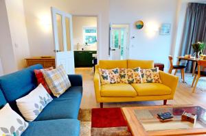 a living room with a yellow couch and a table at WOODY BAY FALLING WATER 2 Bedrooms in Lynton