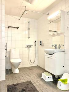 uma casa de banho com um WC, um lavatório e um chuveiro em Guest apartment with view and terrace, Vuosaari, Helsinki, self check-in em Helsinque
