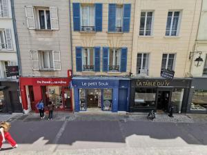 un grupo de edificios con persianas azules en una calle en Wei&Pei Apartment - St Germain En Laye Center -2min RER, en Saint-Germain-en-Laye