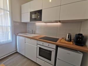 een keuken met witte kasten en een aanrecht bij Wei&Pei Apartment - St Germain En Laye Center -2min RER in Saint-Germain-en-Laye