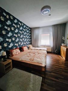 a bedroom with a large bed with a floral wall at Alteschule15 in Leibsch