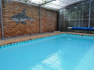 una gran piscina con una pared de ladrillo en Great White Accommodation en Kleinbaai