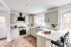 een keuken met witte kasten en een wit aanrecht bij Urban Retreat with Park Views in Derby