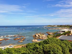 a view of the ocean with rocks in the water at Great White Accommodation in Kleinbaai