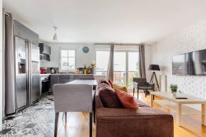 a living room with a couch and a kitchen at Artist Retreat in Noisy-le-Grand