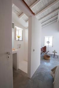 a white room with a desk and a chair at Pensão Agrícola in Cabanas de Tavira +86 photos