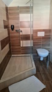 a bathroom with a shower and a toilet at Hotel Sipox in Štrba