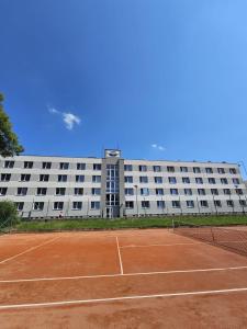 a tennis court in front of a large building at Hotel Buly in Písek