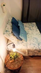 a bed with blue pillows and a table with a lamp at Private rooms in Gothic in Barcelona