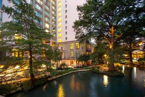 a river in a city with tall buildings at Hotel Contessa - Suites on the Riverwalk in San Antonio