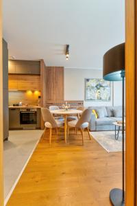 eine Küche und ein Wohnzimmer mit einem Tisch und Stühlen in der Unterkunft King's Square Lux apartment Zlatibor in Zlatibor