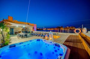 a hot tub on the deck of a cruise ship at night at Valletta Waterfront Villa with Pool and Jacuzzi in Valletta